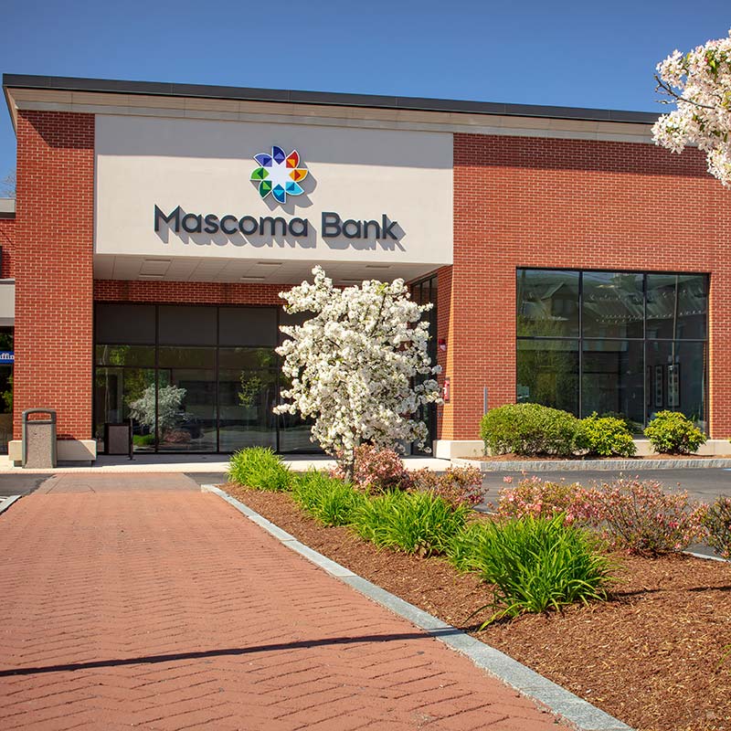 Red brick building with Mascoma Bank logo on front of building above entrance