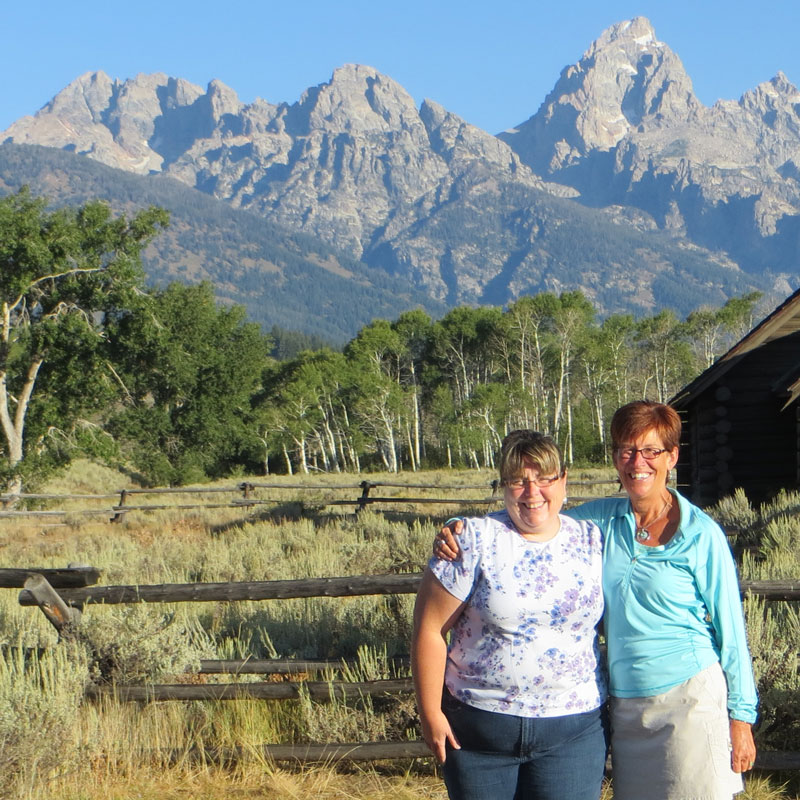 Doreen and Sue posing in front of a the Rocky mountain range