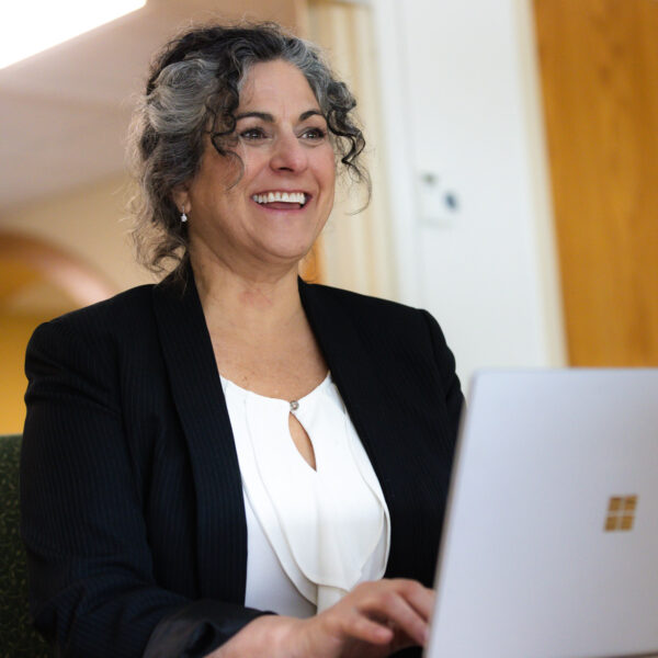 Women smiling behind open laptop